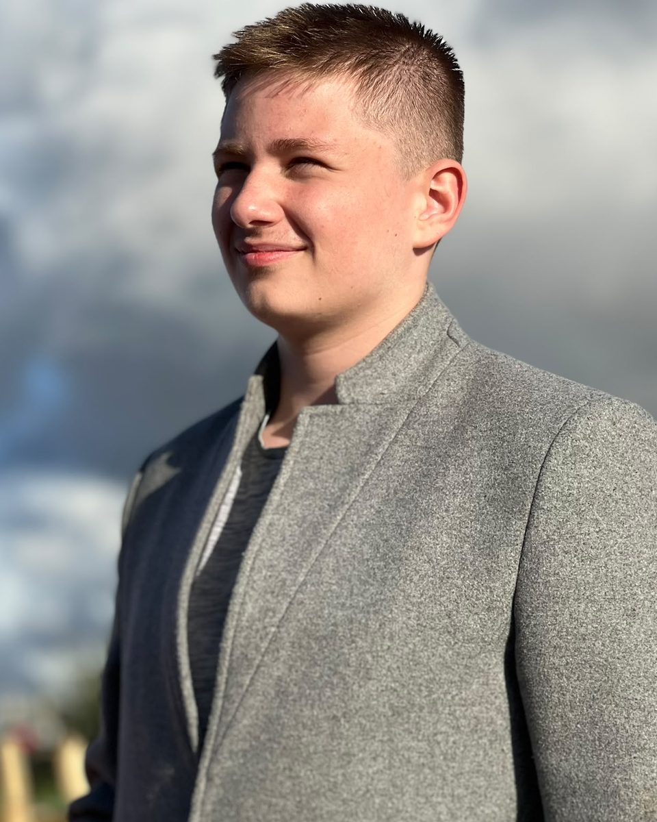 Jenson Bradbury outdoors in a grey jacket, looking to one side